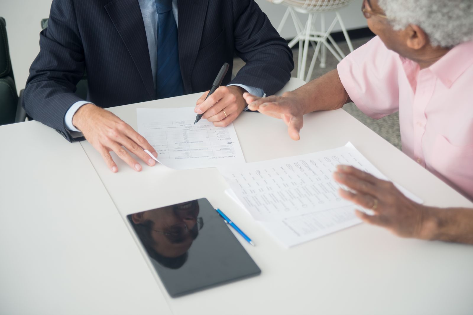 Advisor meeting with an older client at a table